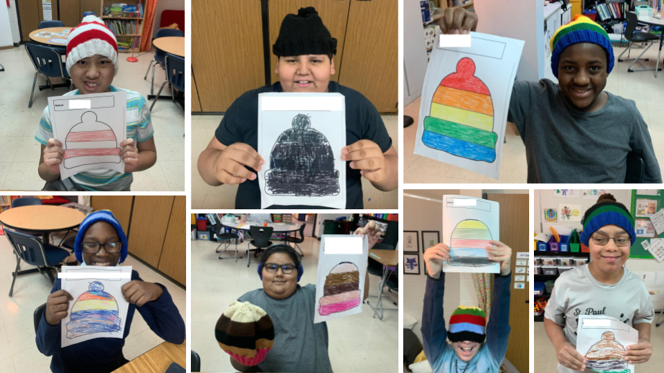 Students holding pictures they colored of winter hats and smiling